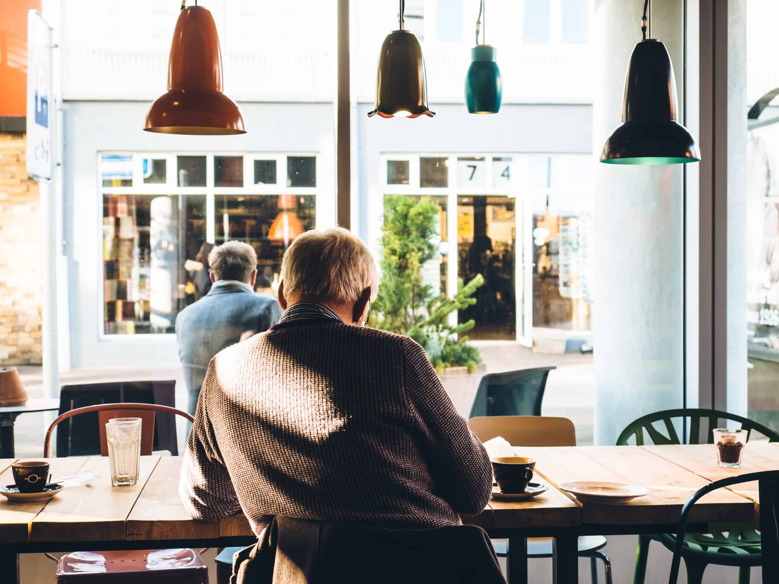 En mann som sitter på en cafe