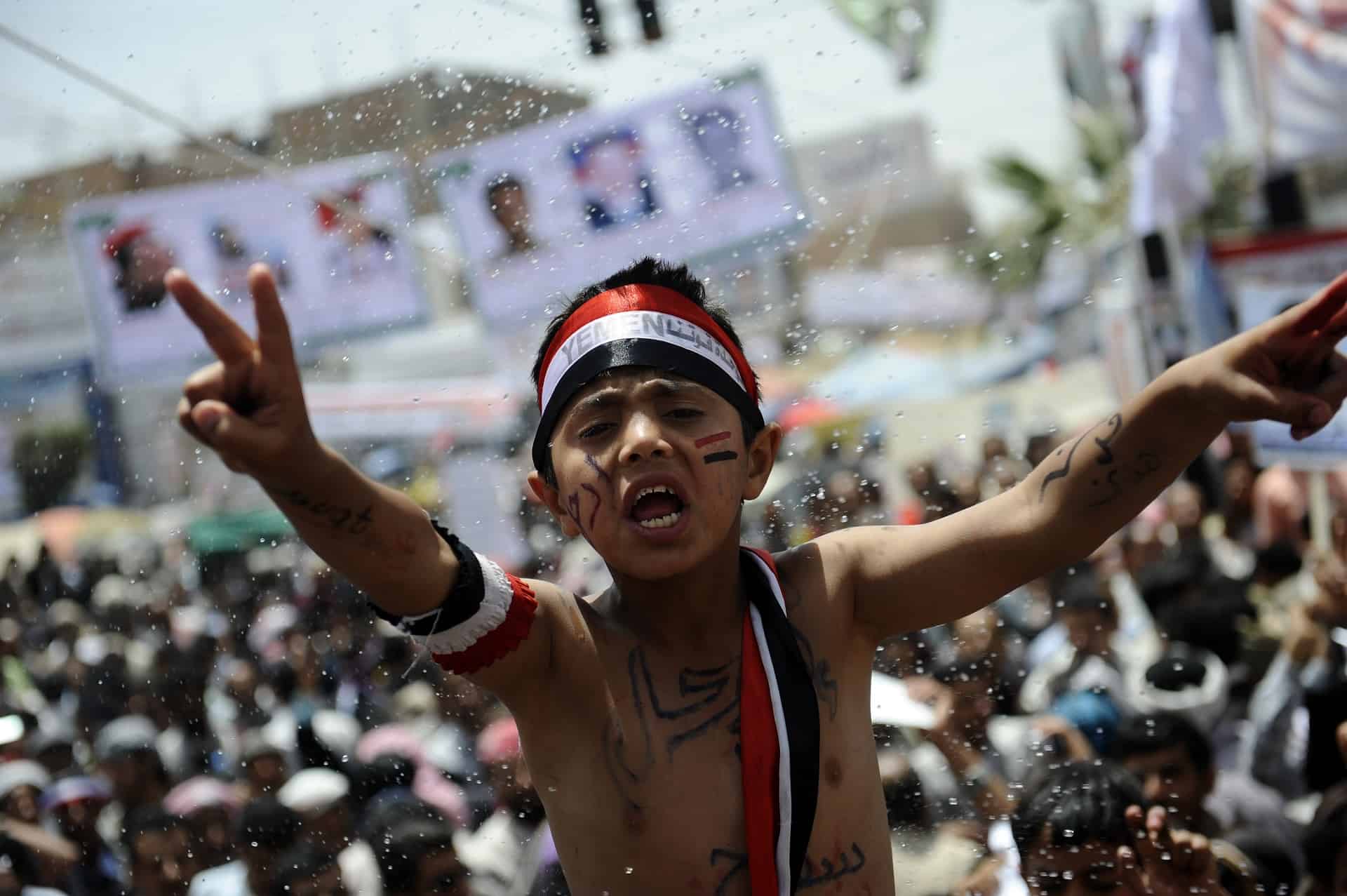 En gutt protesterer sammen med en folkemengde i Sanaa, Jemen, under den arabiske våren, 2011