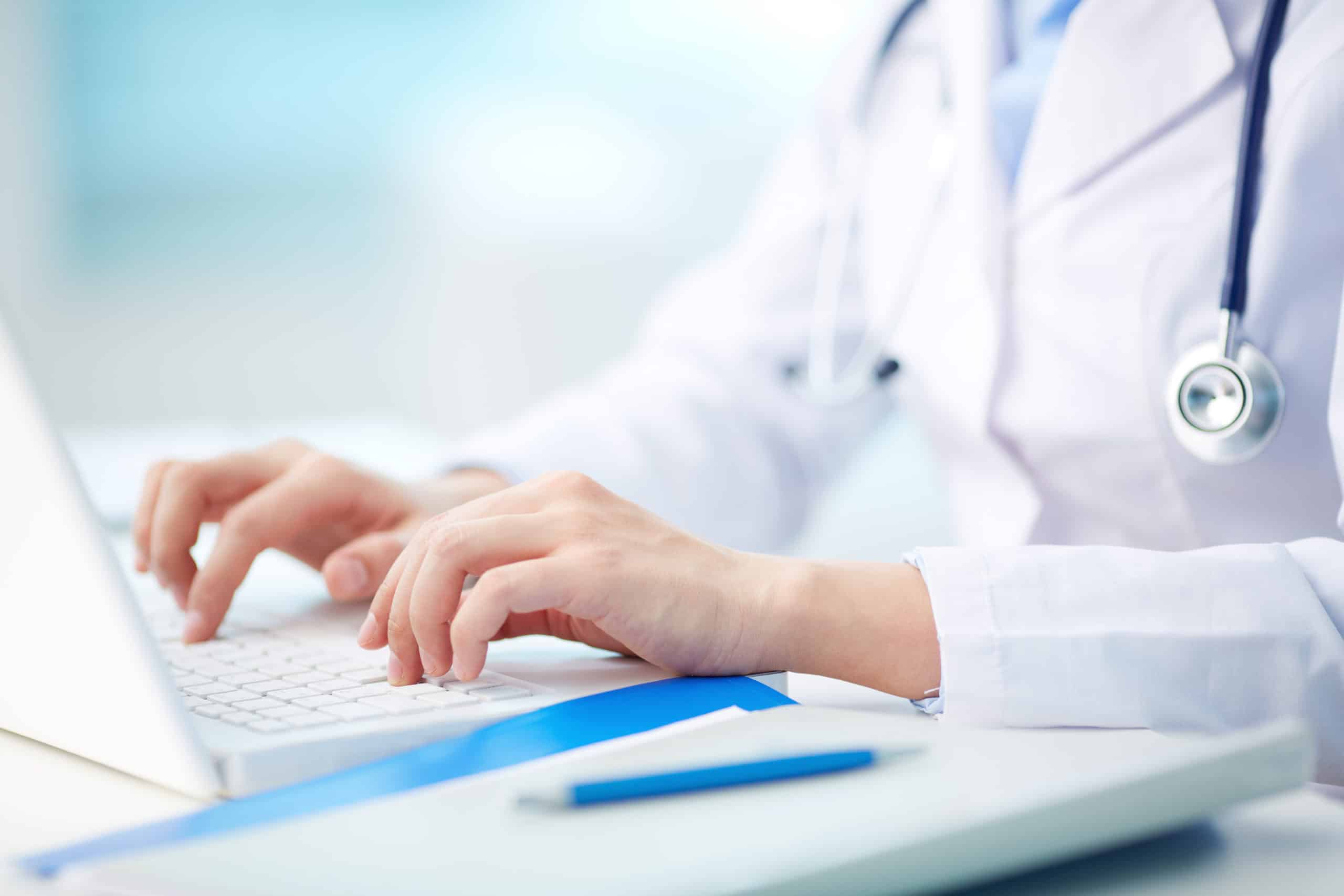 Nærbilde av en medisinsk arbeidstaker skrive på laptop