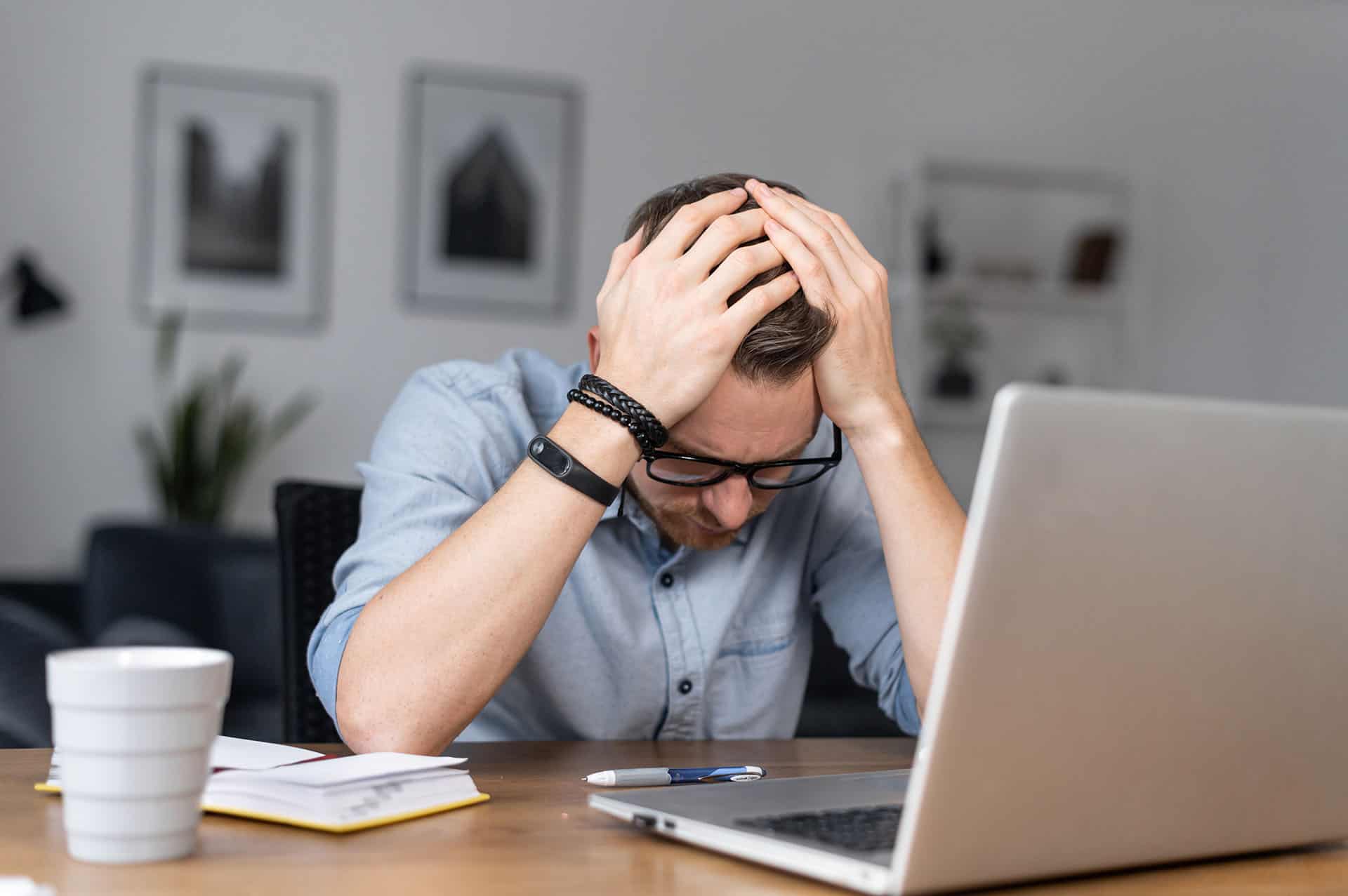 Frustrert ung mann ved PC og skrivebord
