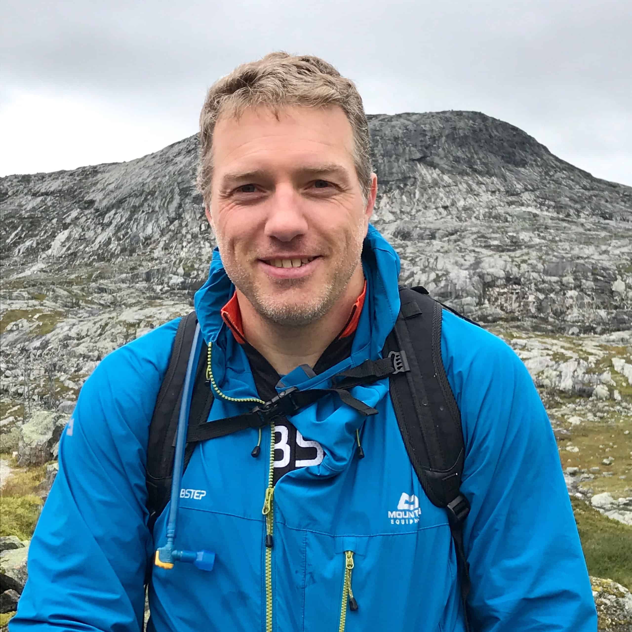 Nicolay er på en fjelltur og ser inn i kamera med et smil