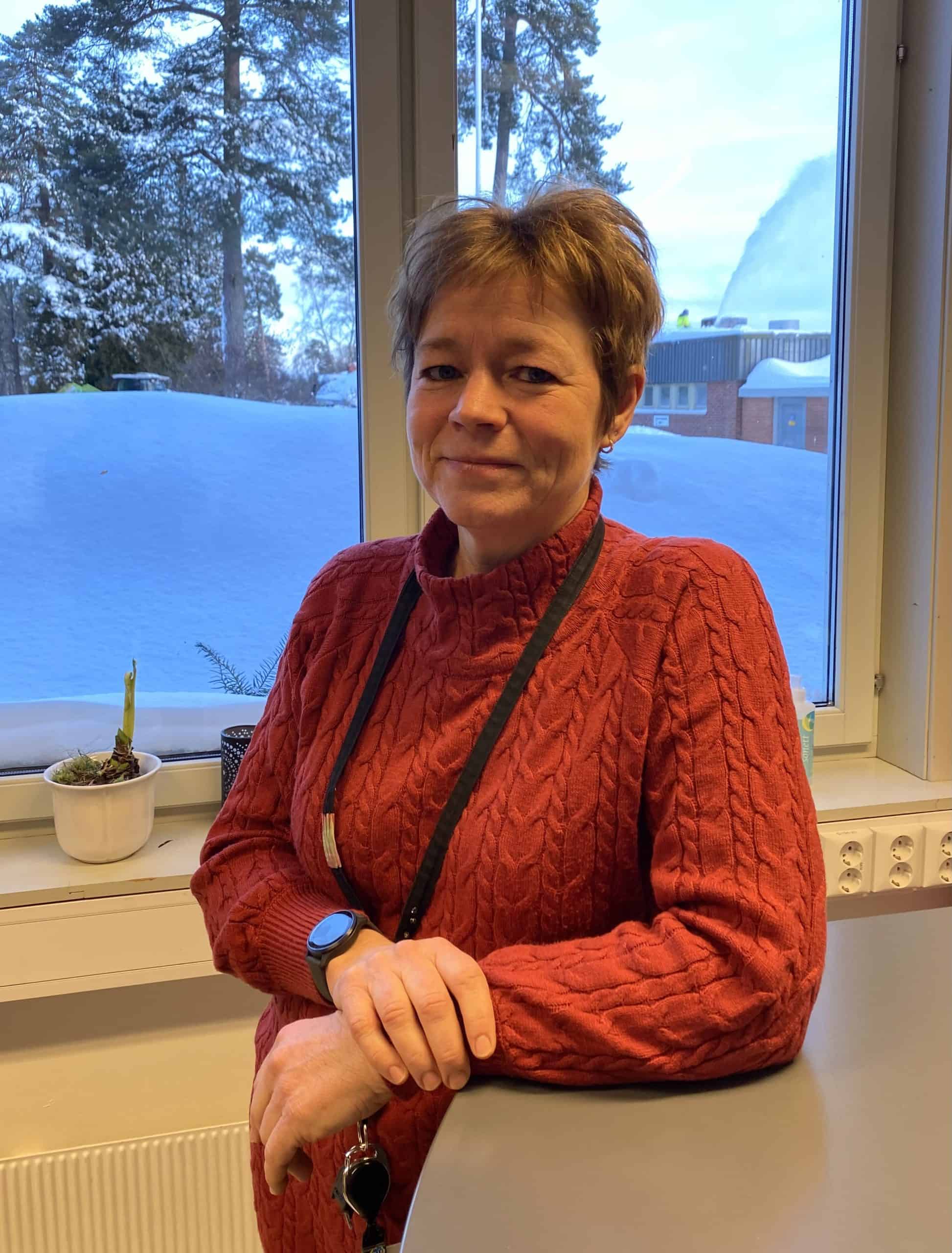 Enhetsleder lener armen på et skrivebord og ser inn i kamera